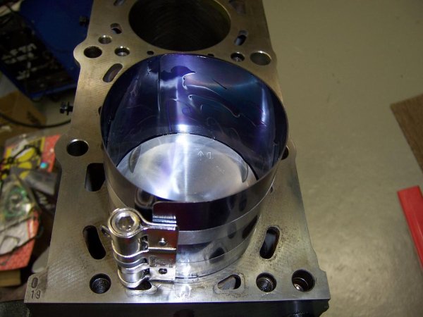 Kolben mit Kolbenringspannband zum montieren